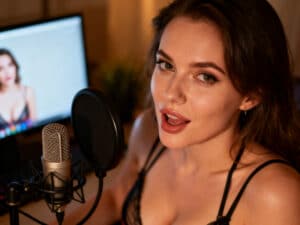 Amteur Sexfilme Darstellerin spricht ins Mikrofon, Computer im Hintergrund